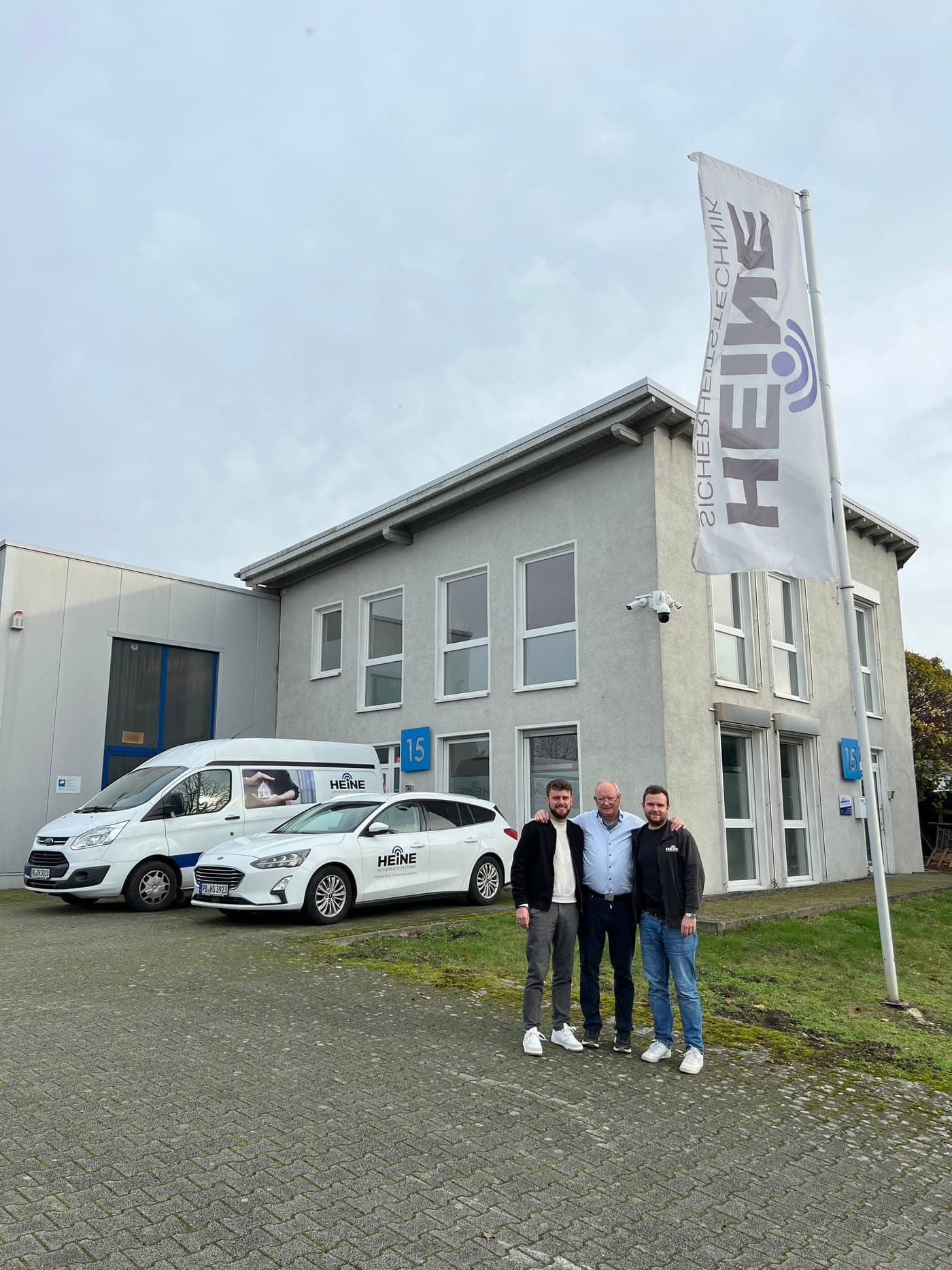 Die Familie Heine vor dem Firmensitz in Borchen – mit eigenen Servicefahrzeugen und Firmenfahne